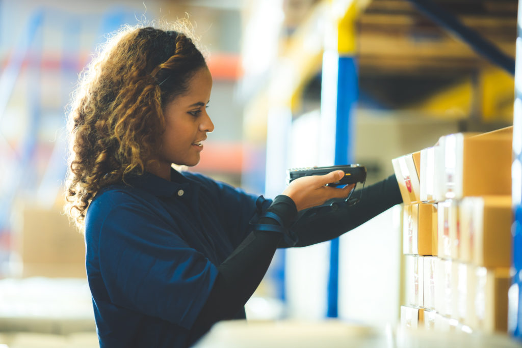 Warehouse employee scanning barcodes to utilize FIFO inventory management system